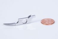 CNC Machined end effector of a medical device next to penny